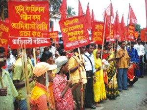 Indigenous people under the banner of Jatiya Adibashi Parishad (JAP) carry placards demanding protection of their rights and protesting attacks o­n the community as they start a march yesterday from Porsha upazila to Naogaon town. Photo: STAR